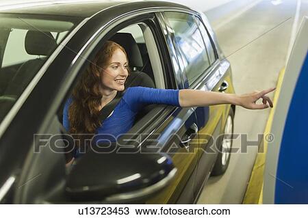 Stock Image - Young woman parking car. Fotosearch