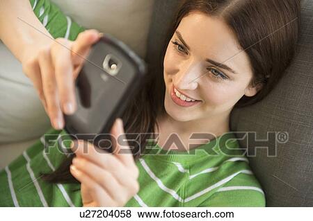 Young woman using cell phone View Large Photo Image Stock Photo - Young woman using cell phone. Fotosearch