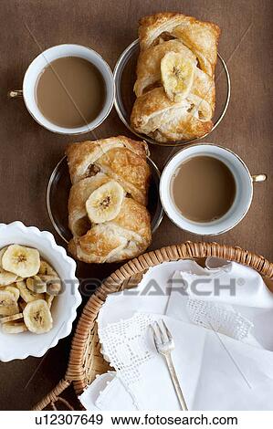 Stock Photo - Baked pastries with banana and coffee. Fotosearch