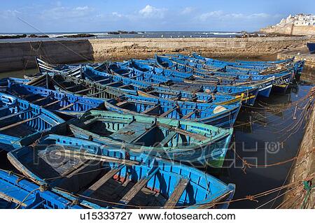 Stock Photo - Blue boats docked in harbor. Fotosearch