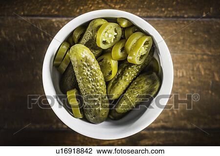 Stock Image - Bowl of pickles and chili pepper slices. Fotosearch