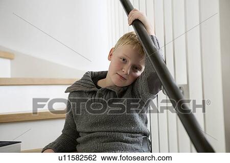 Stock Image - Boy sitting on stairs. Fotosearch