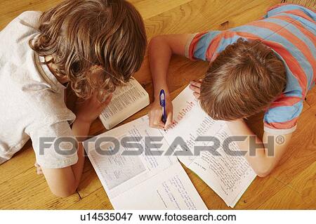 Stock Photo - Boys studying together on floor. Fotosearch