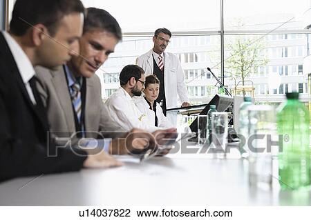 Business people talking at desk View Large Photo Image Stock Image - Business people talking at desk. Fotosearch