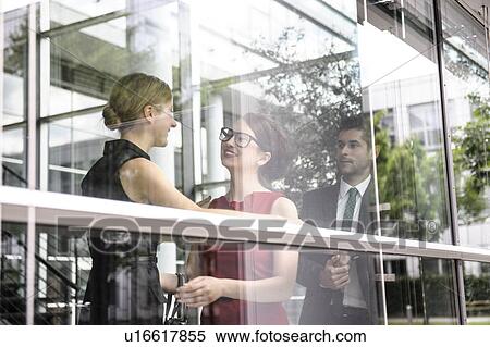 Business people talking by window View Large Photo Image Stock Photography - Business people talking by window. Fotosearch