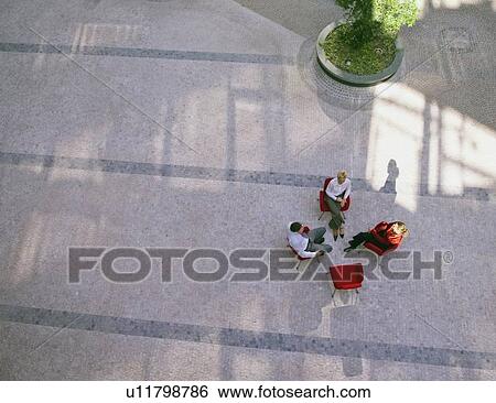 Stock Photograph - Business people talking in office lobby. Fotosearch