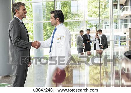 Businessman and doctor shaking hands View Large Photo Image Stock Image - Businessman and doctor shaking hands. Fotosearch