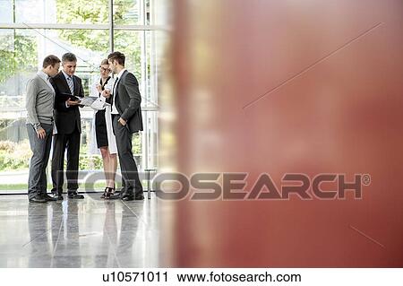 Stock Image - Businessmen and doctor talking. Fotosearch