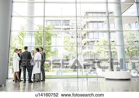 Stock Image - Businessmen and doctors talking. Fotosearch