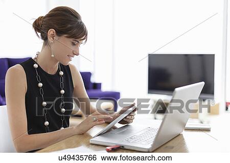 Stock Photograph - Businesswoman using tablet computer. Fotosearch