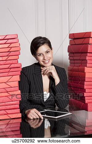 Stock Image - Businesswoman with stacks of folders. Fotosearch