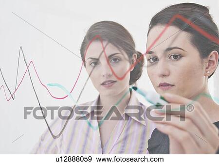 Stock Photo - Businesswomen making graph on glass. Fotosearch