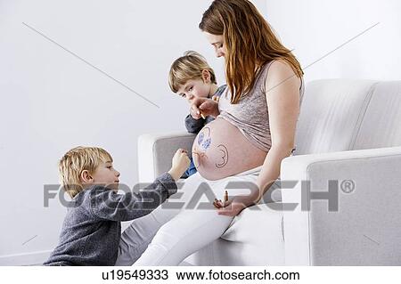 Stock Image - Children drawing on pregnant mother. Fotosearch