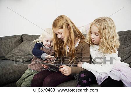 Children using tablet computer on sofa View Large Photo Image Stock Image - Children using tablet computer on sofa. Fotosearch