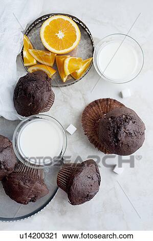 Stock Image - Chocolate muffins with milk and orange. Fotosearch