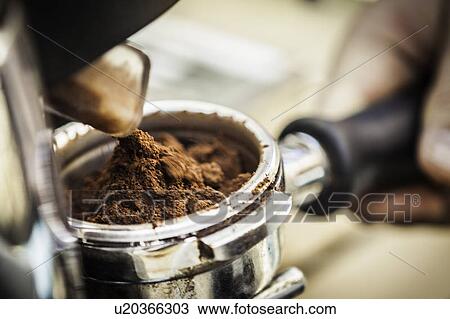 Stock Image - Close up of espresso grounds in machine. Fotosearch