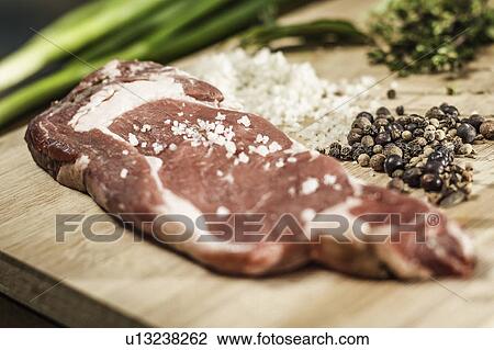 Stock Image - Close up of seasoned meat on board. Fotosearch