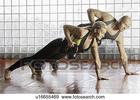 Couple lifting weights in gym View Large Photo Image Stock Photo - Couple lifting weights in gym. Fotosearch