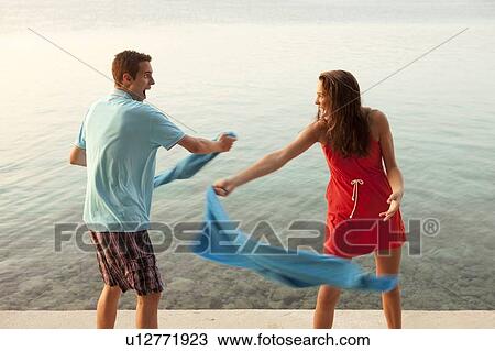 Stock Image - Couple snapping towels at each other. Fotosearch