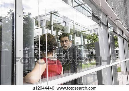 Couple standing by window View Large Photo Image Stock Photograph - Couple standing by window. Fotosearch