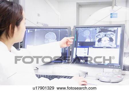 Stock Photo - Doctor examining x-rays on computer. Fotosearch