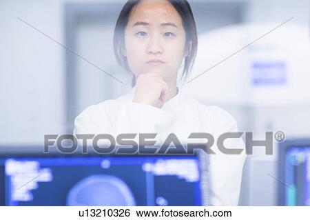 Stock Photograph - Doctor standing in CT scanner room. Fotosearch