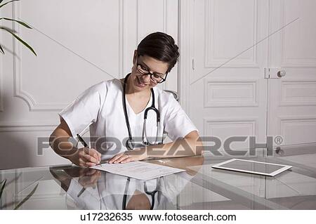 Doctor taking notes in office View Large Photo Image Stock Photography - Doctor taking notes in office. Fotosearch