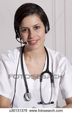 Stock Photo - Doctor talking on headset in office. Fotosearch