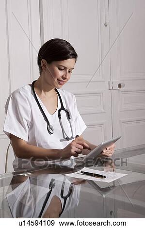 Doctor using tablet computer in office View Large Photo Image Stock Photo - Doctor using tablet computer in office. Fotosearch