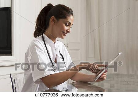 Doctor using tablet computer in office View Large Photo Image Stock Photograph - Doctor using tablet computer in office. Fotosearch