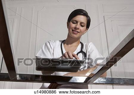 Doctor using tablet computer in office View Large Photo Image Stock Photograph - Doctor using tablet computer in office. Fotosearch