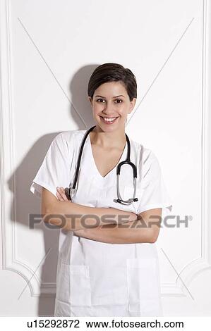 Doctor wearing stethoscope in office View Large Photo Image Stock Image - Doctor wearing stethoscope in office. Fotosearch