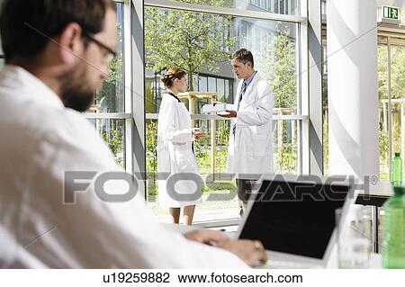Stock Image - Doctors talking in conference room. Fotosearch