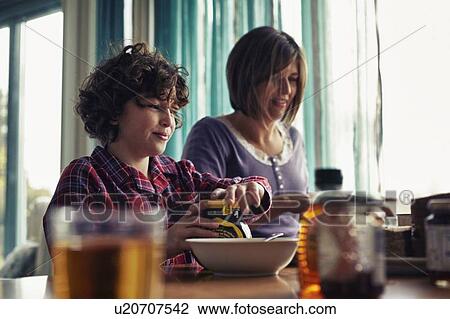 Stock Image - Family eating together at table. Fotosearch