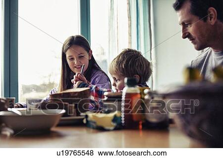 Family eating together at table View Large Photo Image Stock Photo - Family eating together at table. Fotosearch