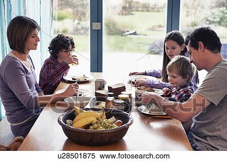 Family having dinner together at table View Large Photo Image Stock Photography - Family having dinner together at table. Fotosearch