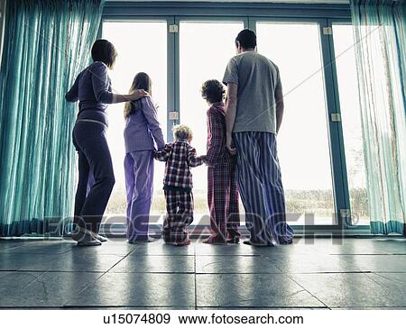 Family in pajamas looking out window View Large Photo Image Stock Photo - Family in pajamas looking out window. Fotosearch