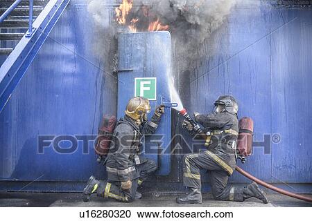 Stock Image - Firefighters in simulation training. Fotosearch