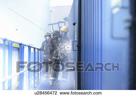 Stock Image - Firefighters in simulation training. Fotosearch