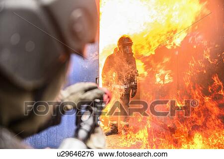 Stock Photograph - Firefighters in simulation training. Fotosearch