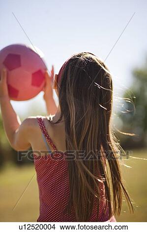 Girl carrying soccer ball in field View Large Photo Image Picture - Girl carrying soccer ball in field. Fotosearch