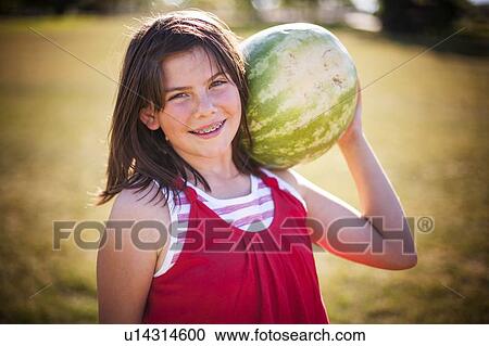 Girl carrying watermelon in field View Large Photo Image Stock Image - Girl carrying watermelon in field. Fotosearch