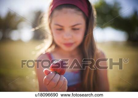 Girl eating strawberry outdoors View Large Photo Image Stock Image - Girl eating strawberry outdoors. Fotosearch