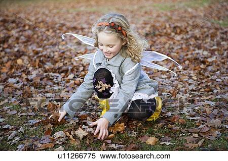 Girl in fairy wings playing in leaves View Large Photo Image Stock Photography - Girl in fairy wings playing in leaves. Fotosearch