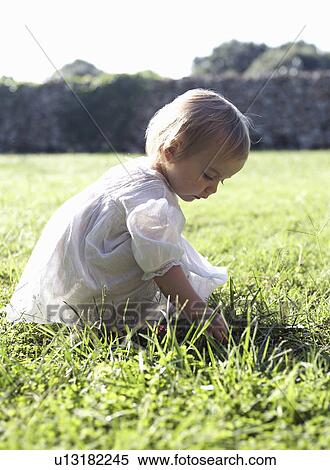 Stock Photography - Girl playing in tall grass. Fotosearch