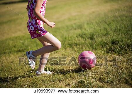 Stock Photo - Girl playing soccer in field. Fotosearch