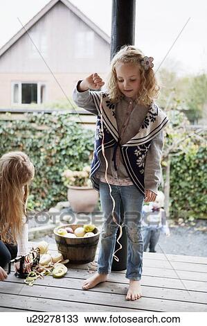 Girl playing with fruit peel on patio View Large Photo Image Stock Image - Girl playing with fruit peel on patio. Fotosearch