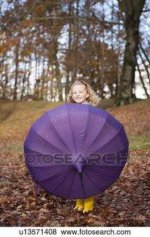 Stock Photo - Girl playing with umbrella in park. Fotosearch