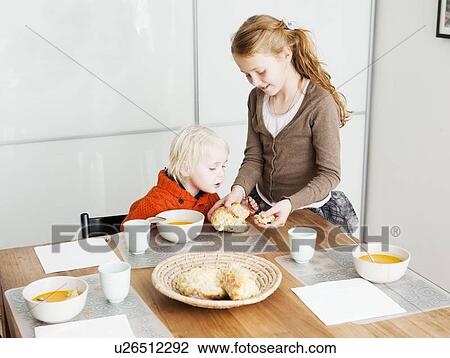 Girl serving brother lunch at table View Large Photo Image Stock Image - Girl serving brother lunch at table. Fotosearch