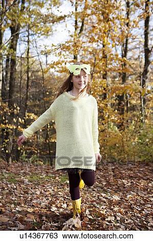 Stock Image - Girl wearing butterfly mask in park. Fotosearch